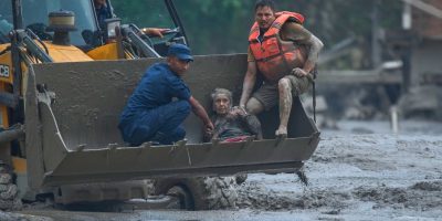 Rescuers-use-an-earthmover-to-carry-a-victim-of-flash-flooding-to-safety-along-the-Trishuli-RiverAP.jpeg