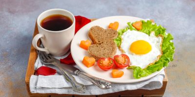 breakfast-valentine-s-day-fried-eggs-bread-shape-heart-fresh-vegetables-scaled.jpg