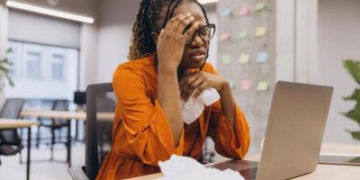 professionalafrican-american-woman-worker-experiencing-workplace-stress-typing-on-laptop-amid-scatte.jpeg