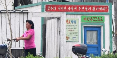 woman-walking-bicycle-near-neighbor-near-checkpoint-china-north-korea-border.jpg